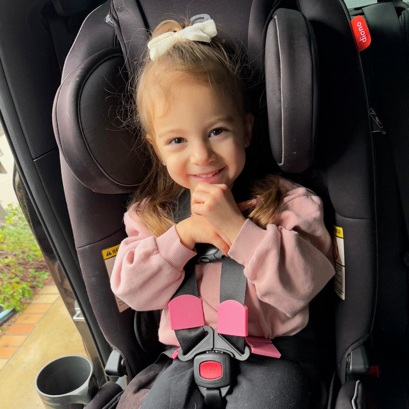 Happy child safely buckled with BuckleBuddeez